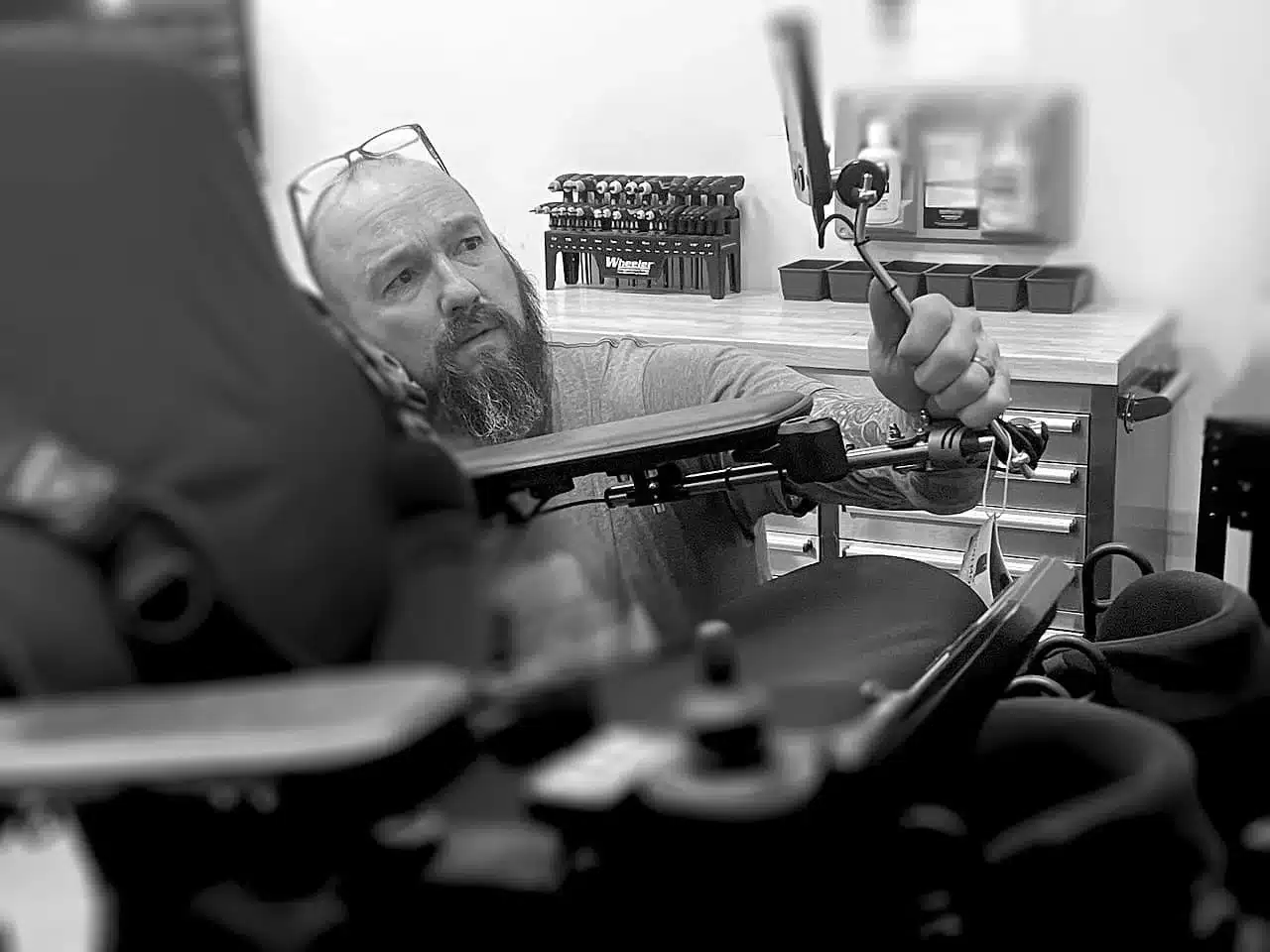 get_start_img Our expert adjust equipment on a wheelchair in a workshop, surrounded by tools and storage, focused on enhancing mobility.